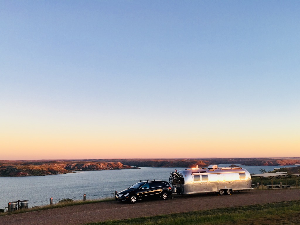 Vintage Airstream travel trailer towed through mountain highway