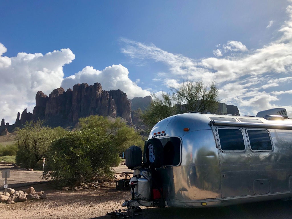 Airstream travel trailer surrounded by fall foliage