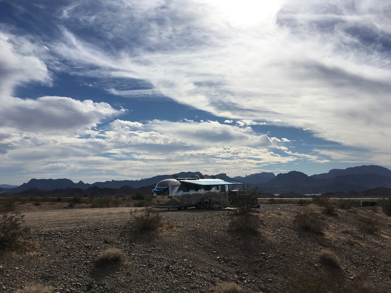 Airstream in desert with mountain backdrop